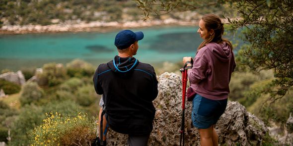 Un couple se tient dans un magnifique parc national en admirant un lac bleu, illustrant la beauté naturelle mise en avant dans le guide de Photobox sur les plus beaux parcs nationaux d'Europe.