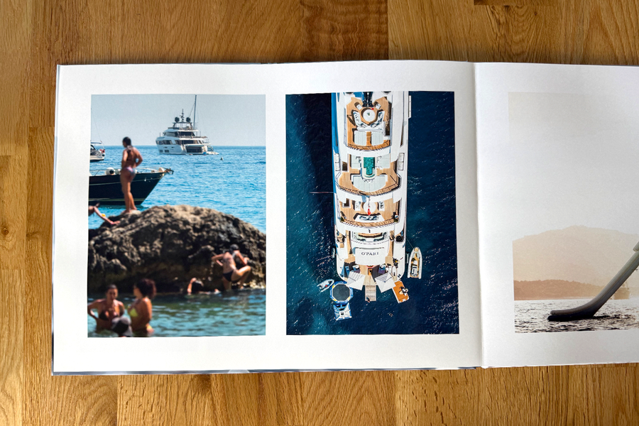 Une double page ouverte du livre photo de Charl van Rooy présente des scènes de vacances à la plage, avec des personnes se relaxant au bord de la mer et un yacht, illustrant la fluidité visuelle de son portfolio photographique.