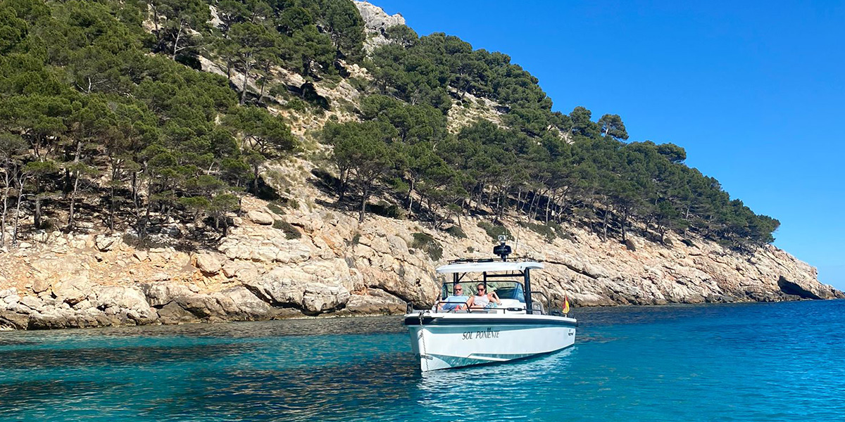Gemma, rédactrice chez Photobox, est assise sur un bateau au large d'Ibiza, présentant ses destinations de vacances préférées en septembre en Europe.