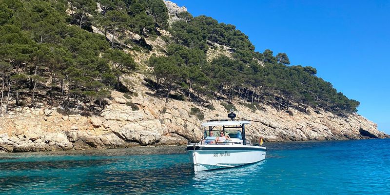 Gemma, rédactrice chez Photobox, est assise sur un bateau au large d'Ibiza, présentant ses destinations de vacances préférées en septembre en Europe.