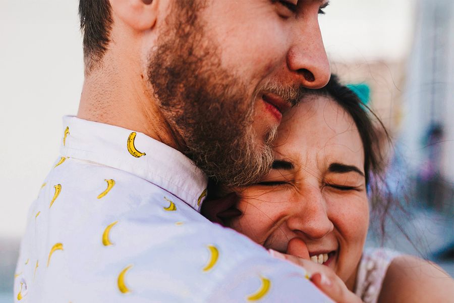 Un couple s'enlace, la femme souriant les yeux fermés, illustrant les idées de Photobox pour savoir quoi écrire dans une carte d'anniversaire de mariage.