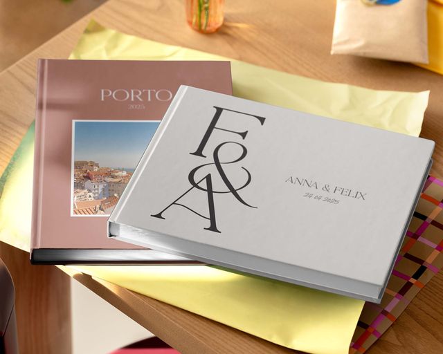 Deux livres photo personnalisés posés sur une table, de tailles et de designs différents.