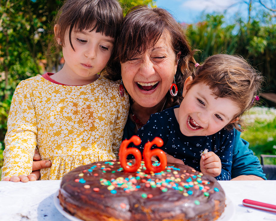 Grand-mère et ses deux petits-enfants soufflant joyeusement les bougies d'anniversaire.