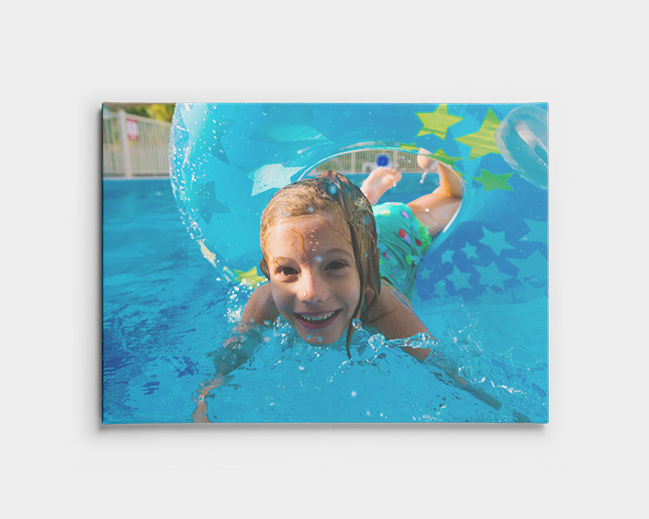 Une photo sur toile d'un enfant nageant sous l'eau dans une piscine.