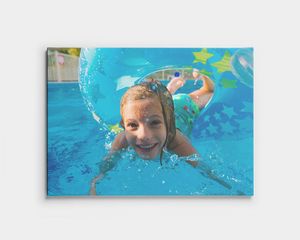 Une photo sur toile d'un enfant nageant sous l'eau dans une piscine.