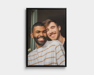 Ue photo sur toile type portrait avec un cadre noir, représentant deux hommes souriants.